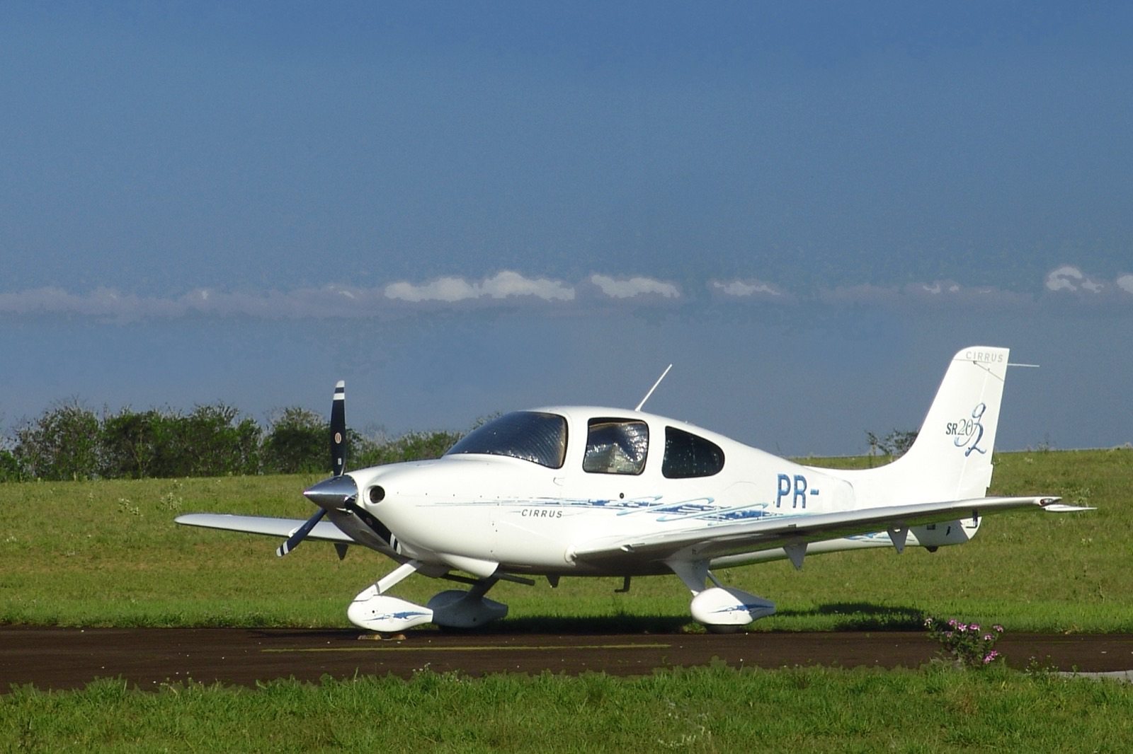 Cirrus SR20 blanc sur taxiway, vue de profil
