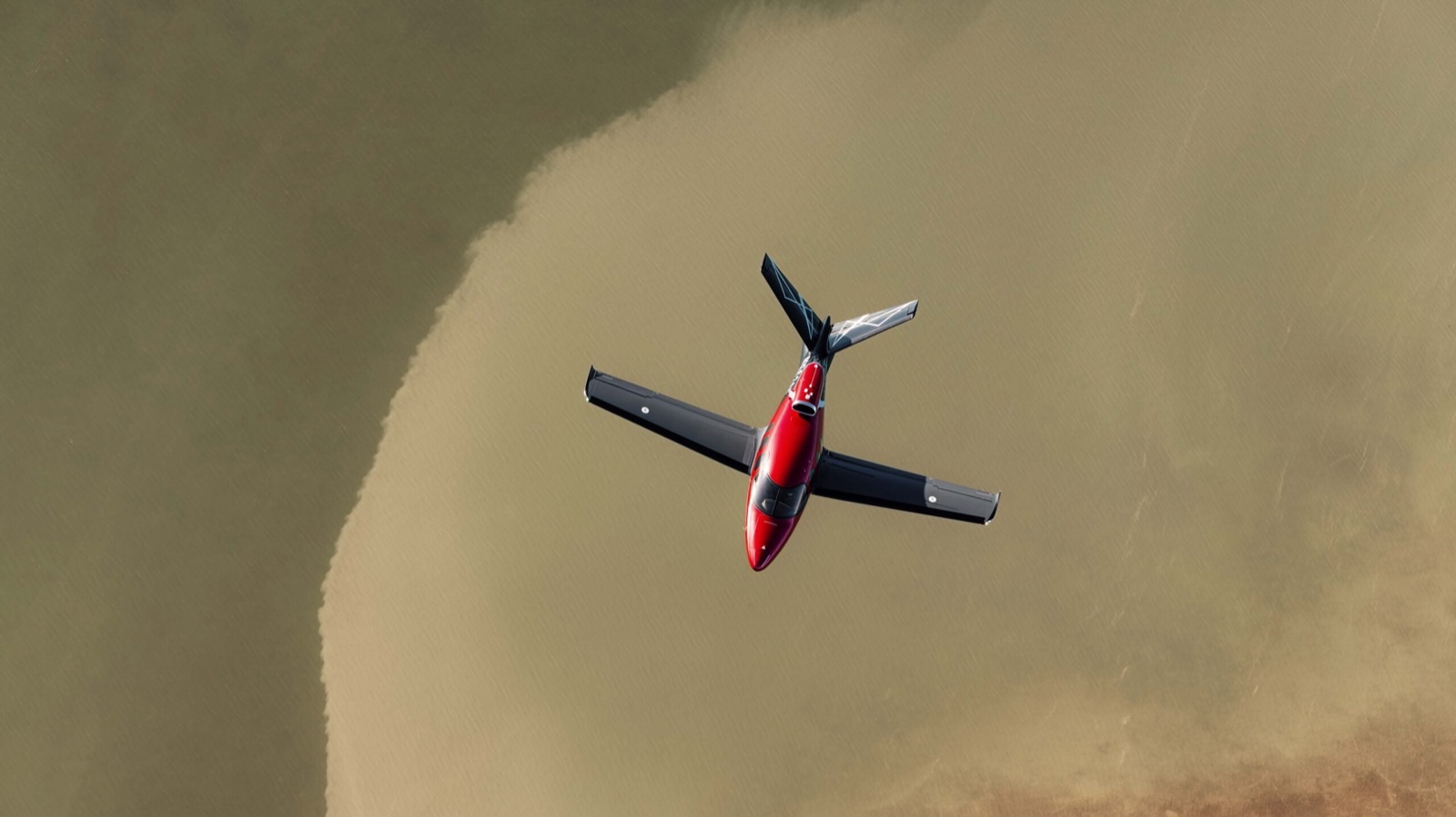 Cirrus SF50 Vision Jet rouge et noir en vol, vue de dessus, empennage en V et réacteur dorsal