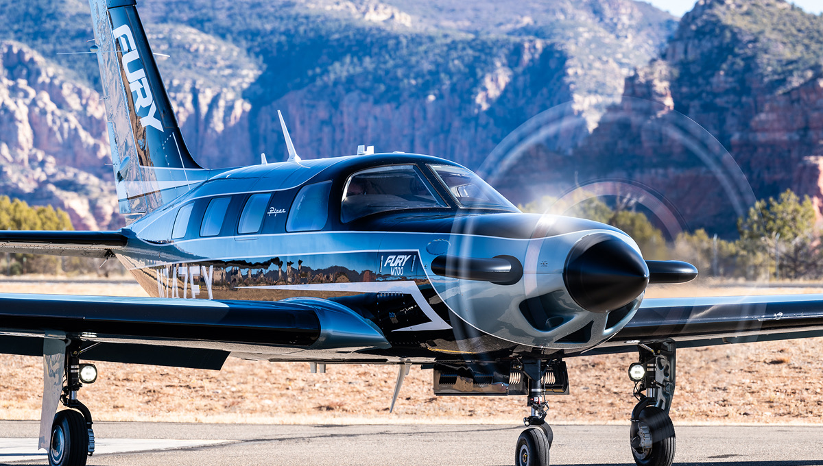 Piper M700 Fury bleu nuit en virage incliné au coucher du soleil