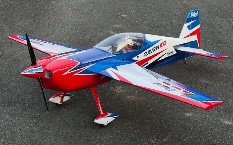 RAVEN 103, grand avion de voltige d'aéromodélisme rouge, blanc et bleu à hélice, vue trois-quarts avant au sol