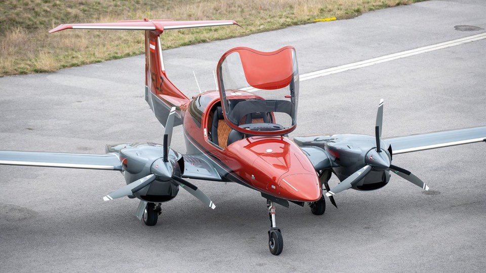 Diamond DA42-VI rouge et blanc au sol verrière ouverte, vue plongeante sur la cabine et les deux moteurs